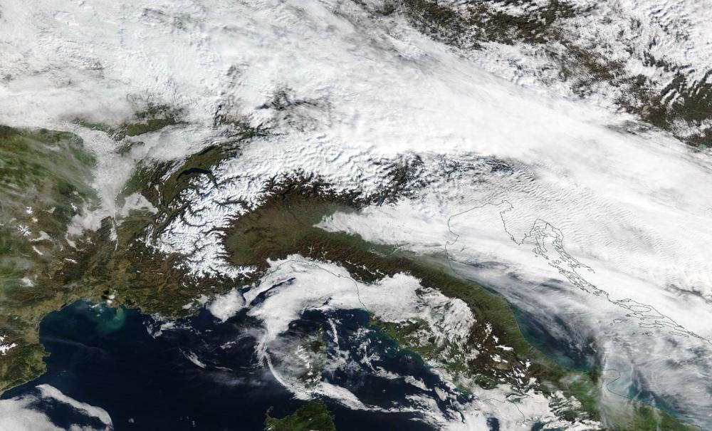 Gisteren piepte de westelijk alpen al onder het wolkendek uit. De besneeuwde bergen zullen komende dagen steeds minder wit kleuren door de hoge temperaturen. (Bron: NASA)