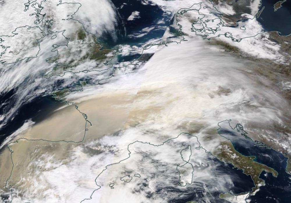 Het Saharastof is door de kleur duidelijk te onderscheiden van de witte wollken (dindsdag 15-03-2022 bron: NASA)